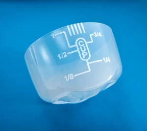 Translucent measuring cap that holds up to 1 cup of chemicals. TruDose Cap™ is on a blue background. Measurements are in cups.